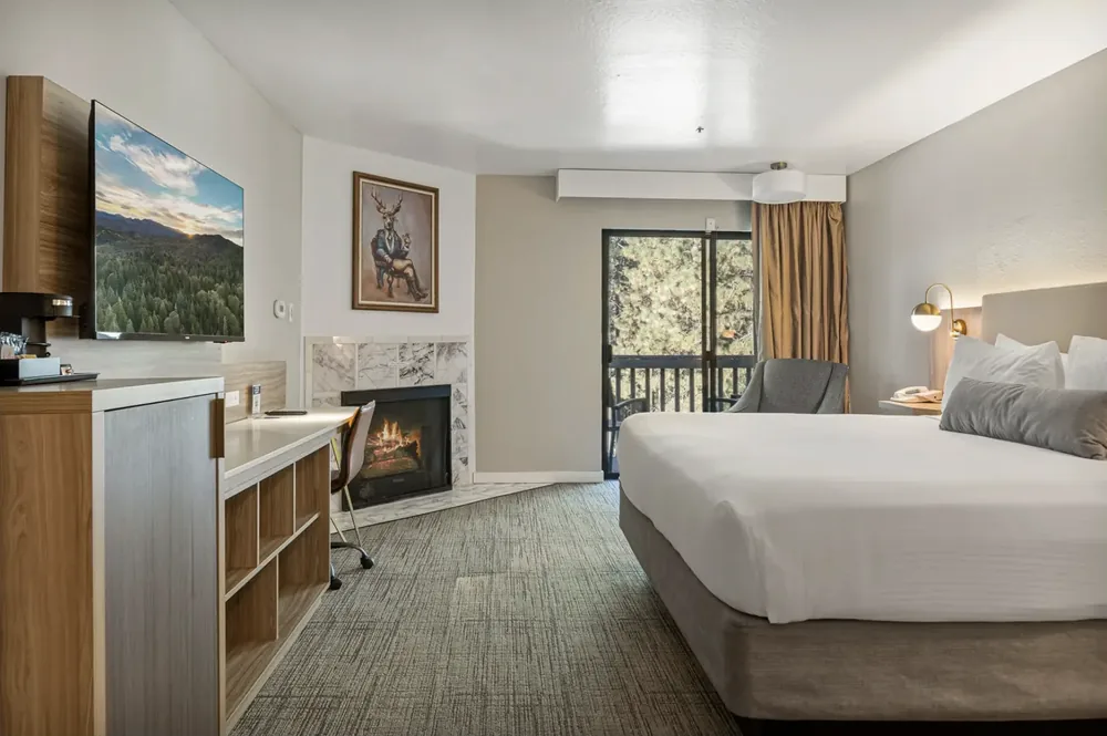Balcony room at Chateau Big Bear with a fireplace and doors onto a wooded balcony